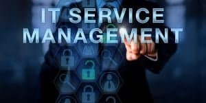 Picture of a man pointing to the screen where appears a digitally illustrated text that says "IT service management", as a visual representation of ITIL vs ITSM.