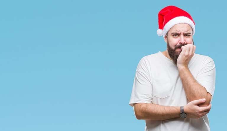 Young caucasian hipster man wearing christmas hat over isolated