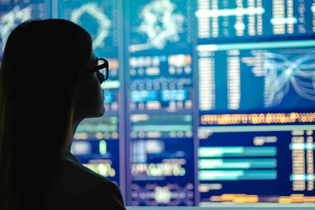 Image of a woman looking at a series of digital boards with information wondering: what is big data?