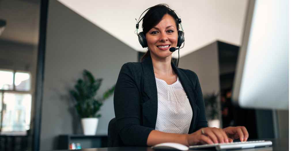 What is the difference between a Service Desk and IT Service Management? Woman with headset smiling