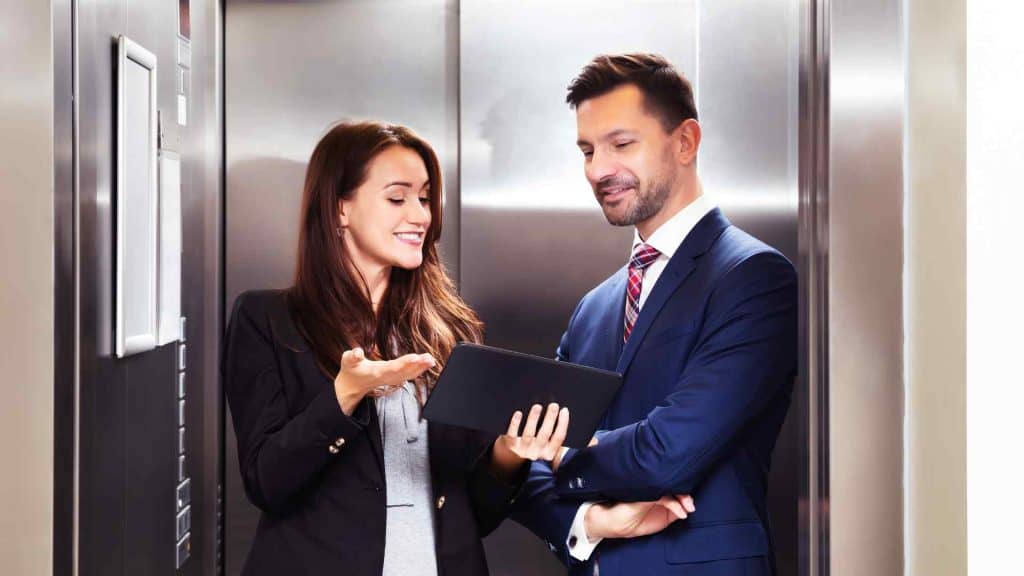 woman making a pitch to a man in an elevator