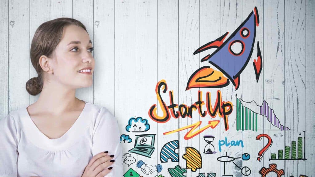 Image of woman loosing at a board with a rocket and the word start up