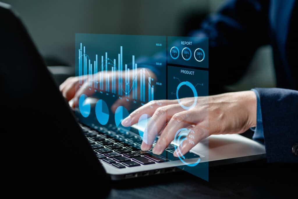 Hands typing on a laptop displaying business continuity software analytics.