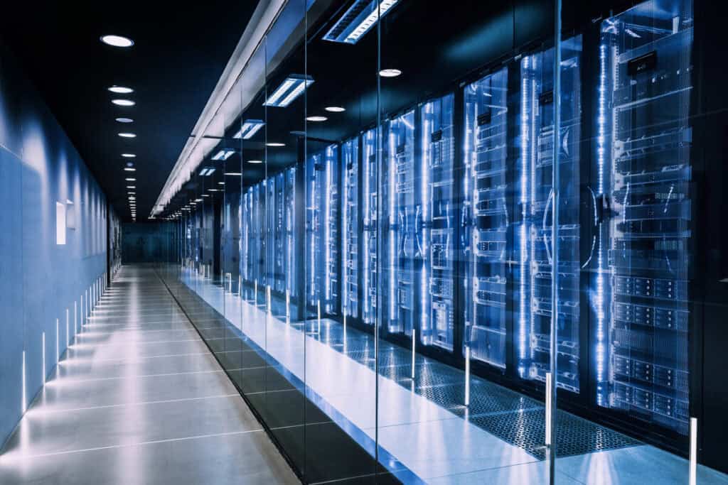 A modern, well-lit data center with rows of server racks, illustrating the elements of a disaster recovery plan.